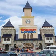 Wrocław Energylandia wita gości zamkową architekturą i kolorowym logo. Tłumy ludzi i zaparkowane samochody sugerują początek ekscytującego dnia.