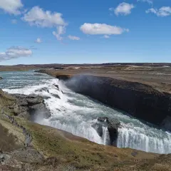 Potężny wodospad Gullfoss, część islandzkiego Złotego Kręgu, z turystami podziwiającymi jego piękno.