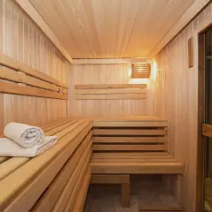 Drewniana sauna z leżankami i ręcznikiem. Idealne miejsce dla relaksu i zdrowia.