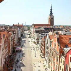 Widok na urokliwe kamieniczki i wieżę kościelną w Elblągu. Idealne miejsce, by odkryć, co zobaczyć w Elblągu i okolicy.