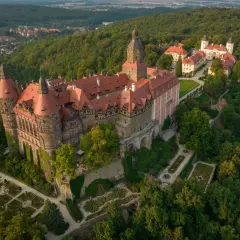 Zamek Książ, jeden z największych pałaców Dolnego Śląska, w otoczeniu bujnej zieleni i malowniczych ogrodów.