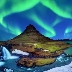 Islandia najpiękniejsze miejsca: wodospad i góra Kirkjufell pod tańczącą zorzą polarną.