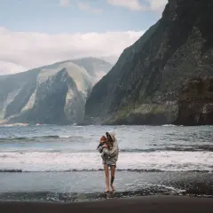 Majestatyczne góry i ocean na Maderze. Kobieta z dzieckiem na czarnej plaży. To idealne miejsce, by zobaczyć na Maderze.