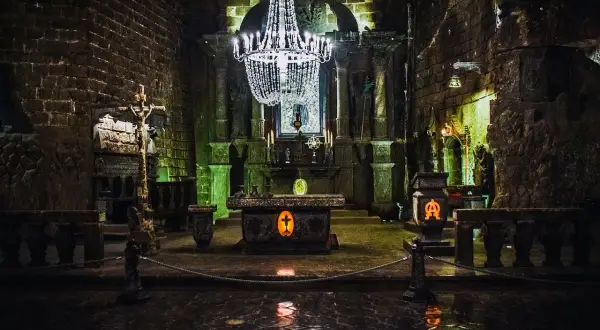 Wnętrze kaplicy w kopalniach soli w Wieliczce i Bochni. Kryształowy żyrandol, ołtarz i krzyż wyrzeźbione w soli.