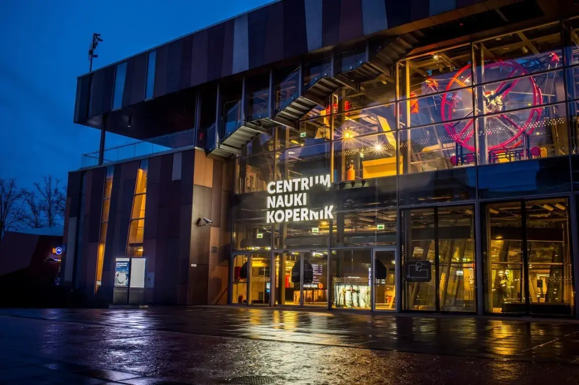Centrum Nauki Kopernik nocą, z widocznym wejściem i fragmentem ekspozycji.