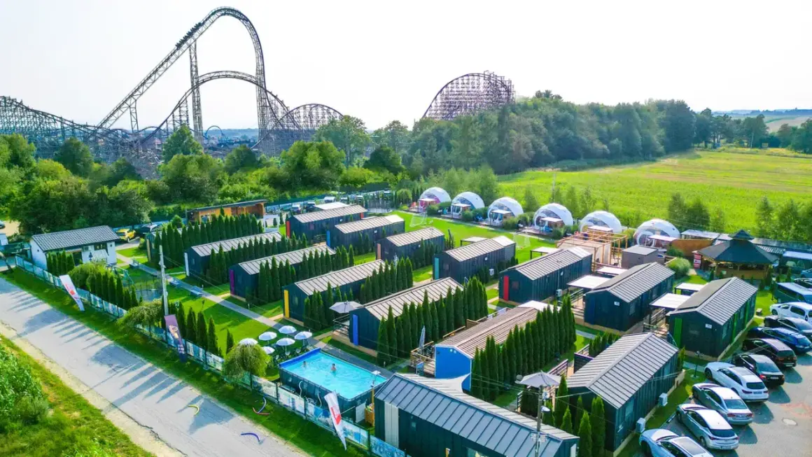 Noc w Energylandii to marzenie! Widok na domki, basen i gigantyczne rollercoastery.