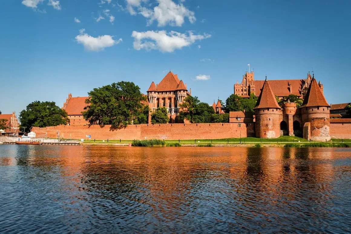 Potężny zamek w Malborku odbija się w wodzie. Zastanawiasz się, ile trwa zwiedzanie zamku w Malborku?