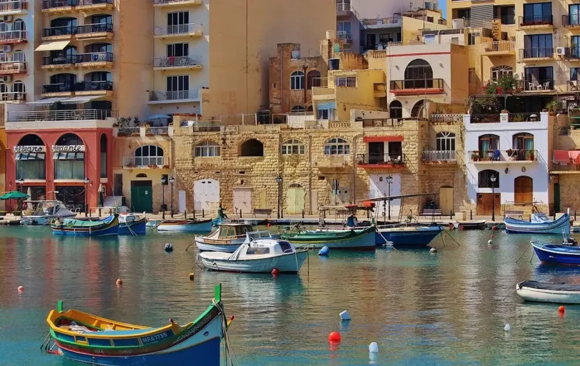 Malta, z kolorowymi łodziami i kamiennymi budynkami. Czy na Maltę potrzebny paszport? Tak, jeśli nie jesteś obywatelem UE.