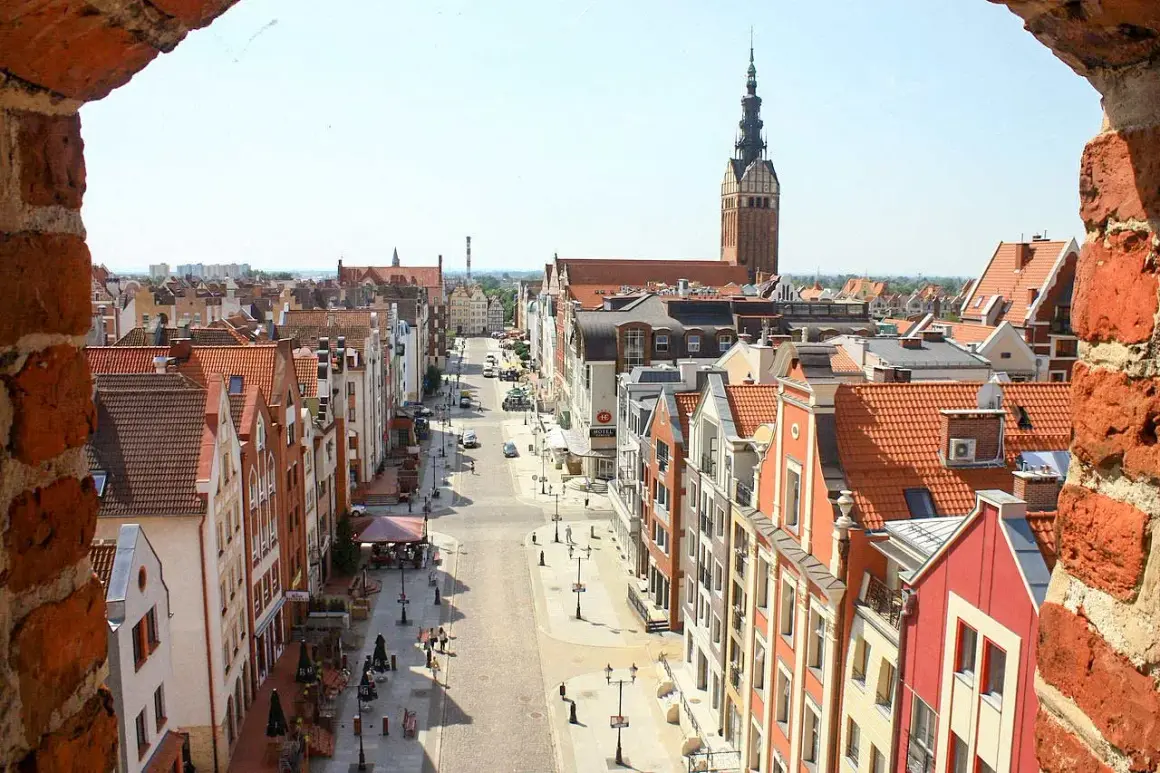 Widok na urokliwe kamieniczki i wieżę kościelną w Elblągu. Idealne miejsce, by odkryć, co zobaczyć w Elblągu i okolicy.