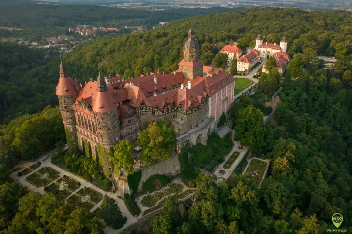 Zamek Książ, jeden z największych pałaców Dolnego Śląska, w otoczeniu bujnej zieleni i malowniczych ogrodów.