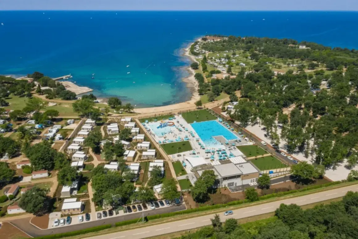Idealne miejsce, gdzie na wakacje: kemping z domkami, baseny i plaża nad turkusowym morzem.