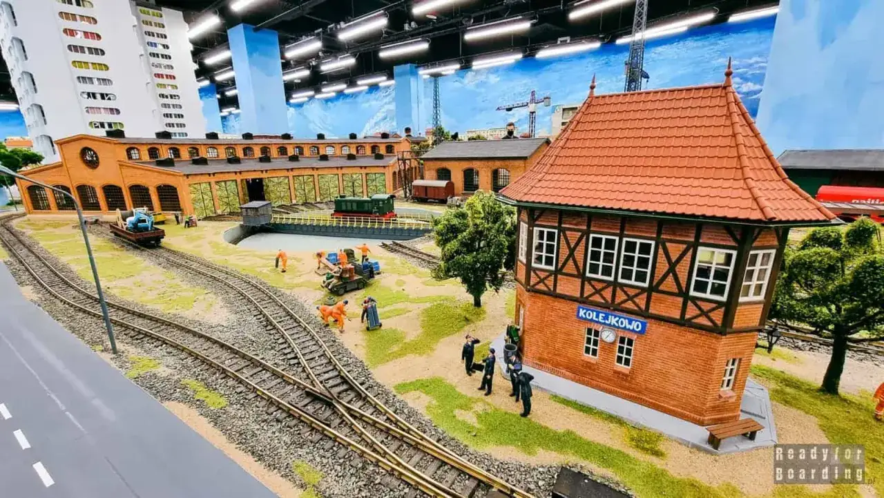 Miniaturowa stacja kolejowa z budynkiem nastawni i lokomotywami, część parku miniatur Wrocław.