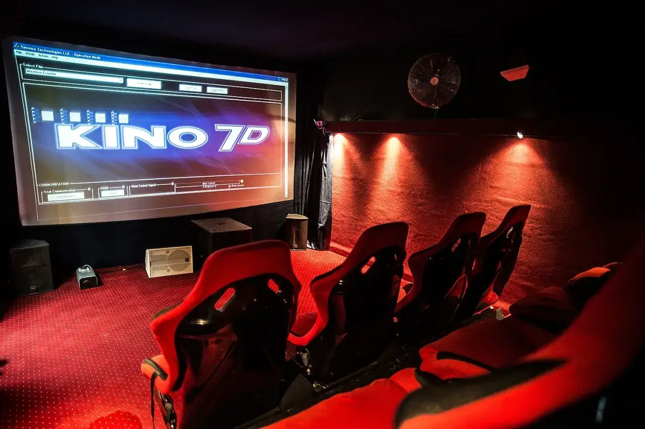 Fotele kinowe w sali KINO 7D, gotowe na seans. Czerwone światła podkreślają futurystyczny wystrój.