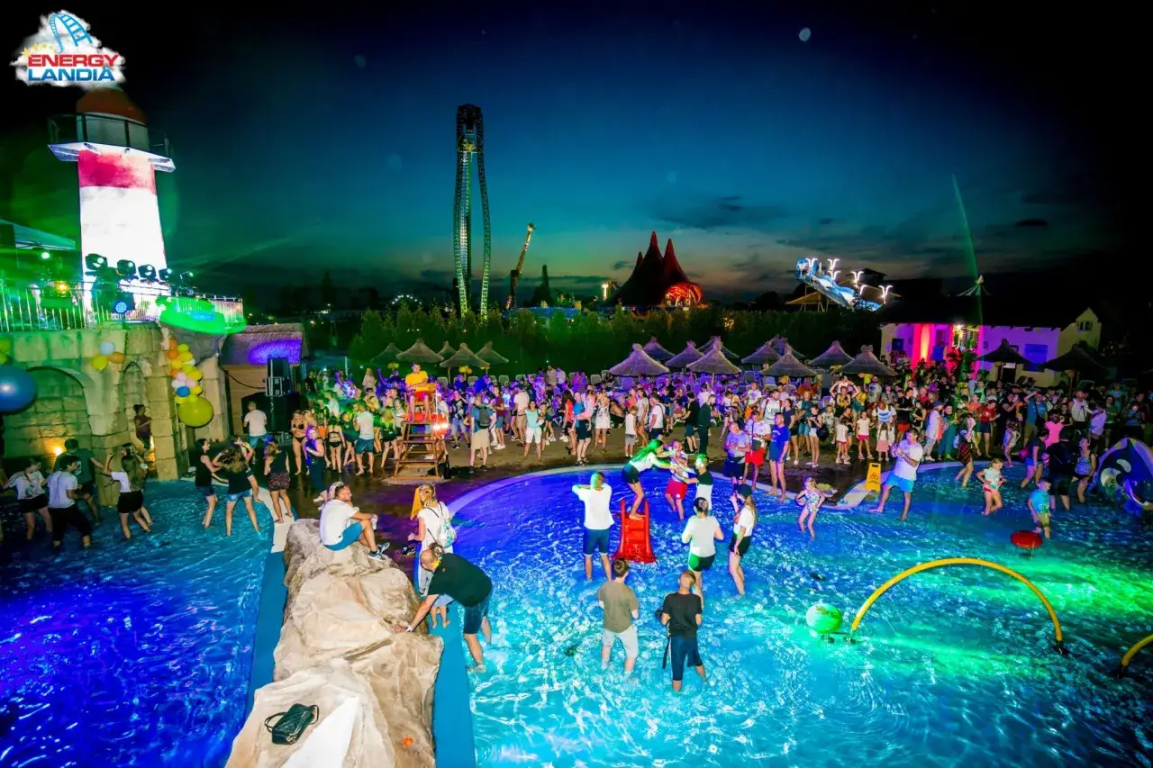 Energylandia nocą tętni życiem. Tłumy bawią się w basenie, a kolorowe światła tworzą magiczną atmosferę.