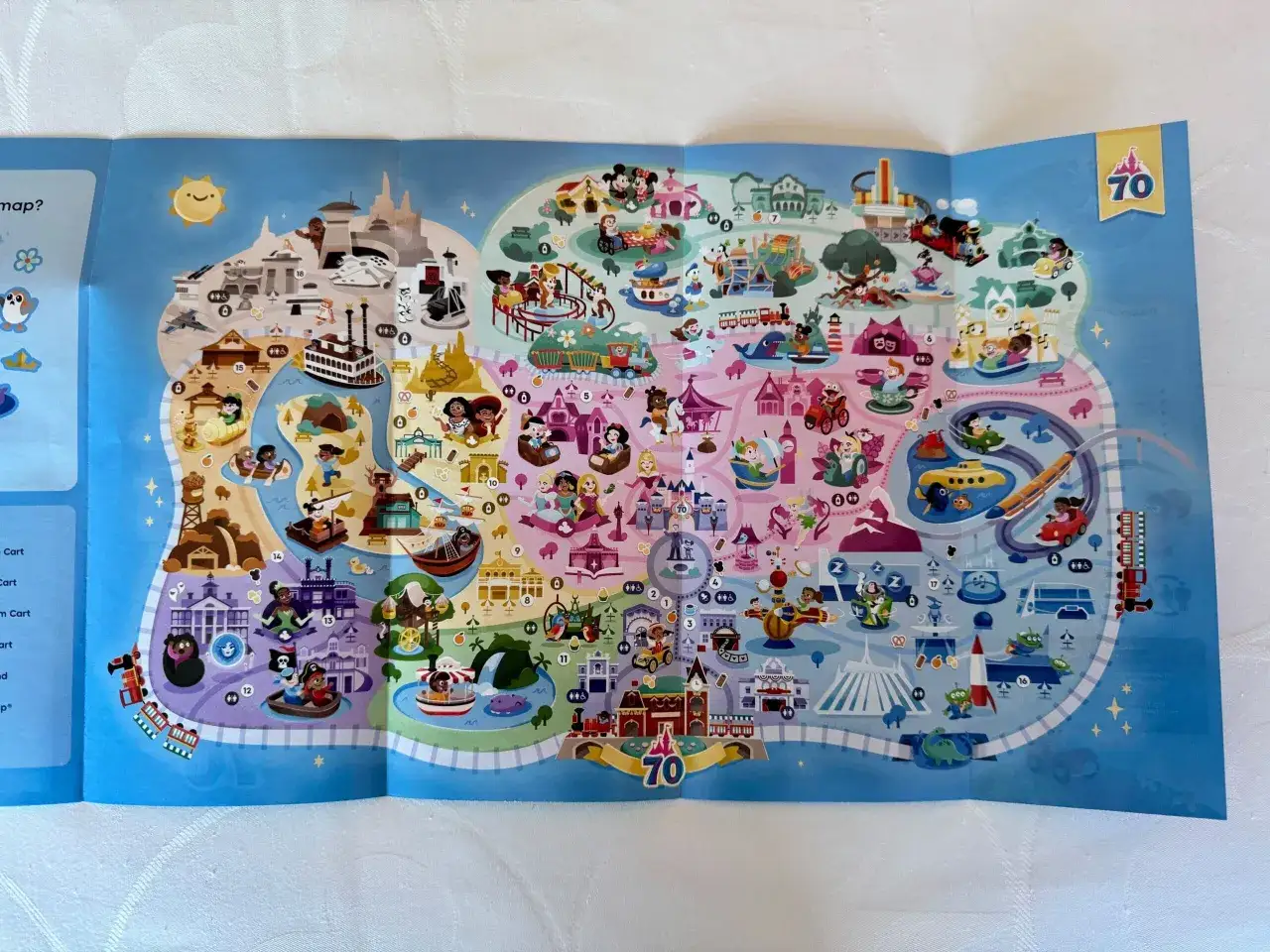 Kolorowa mapa przedstawia różne krainy i atrakcje, sugerując, ile jest Disneylandów na świecie.