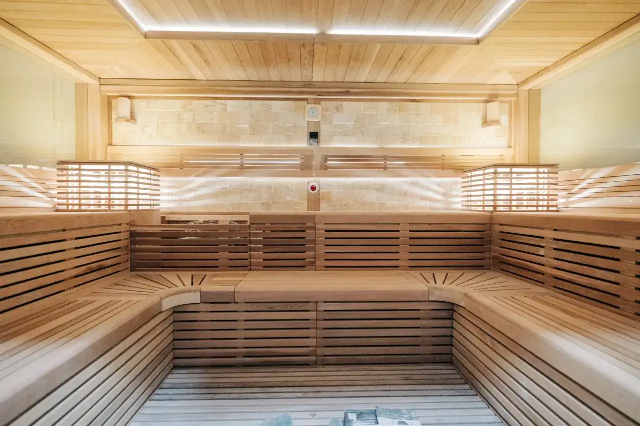 Drewniana, nowoczesna sauna z wielopoziomowymi ławami. Idealne miejsce na relaks, niezależnie czy wolisz saunę suchą czy mokrą.