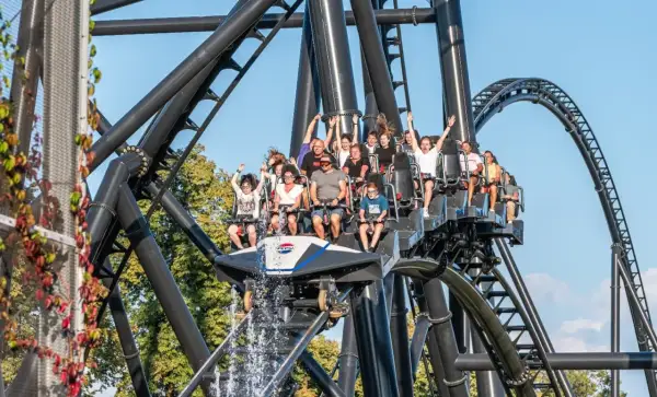 Ludzie na kolejce górskiej w Energylandii, z wodą tryskającą z przodu wagonika. Taka przejażdżka to świetny pomysł na wykorzystanie biletu rocznego Energylandia!